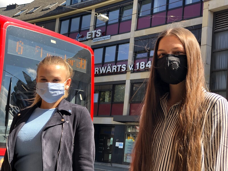 Foto zeigt zwei Personen mit Gesichtsschutz vor dem ETS Firmengebaeude